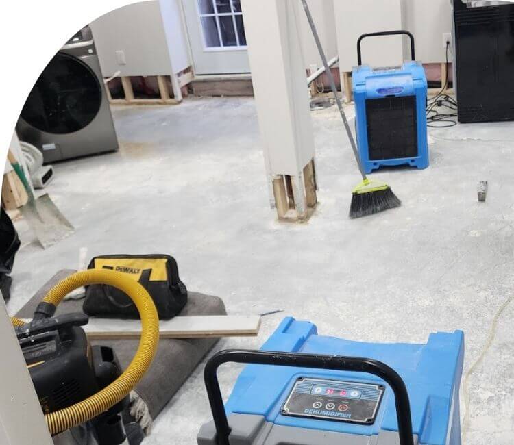 professionals repairing basement water damage with dehumidifiers