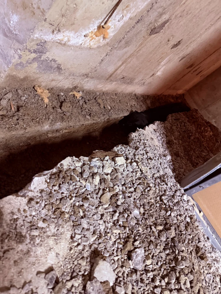 Deep interior trench dug along the foundation wall to fix basement leaks in Aurora.