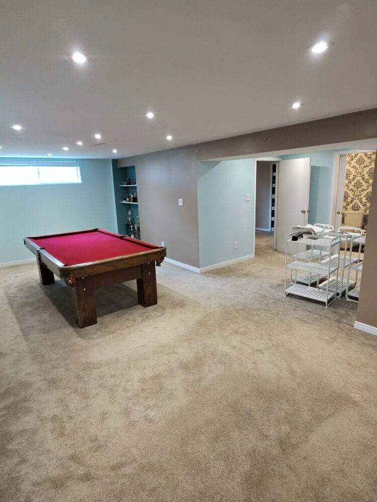 A fully restored, dry, and safe basement recreational room with a pool table in North York, showcasing the final results of DGI Waterproofing's start-to-finish service.